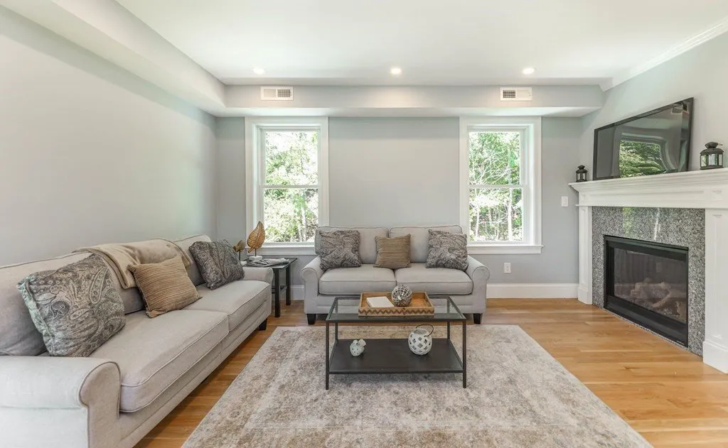 Bright, newly renovated living room with a gas fireplace, staged for sale