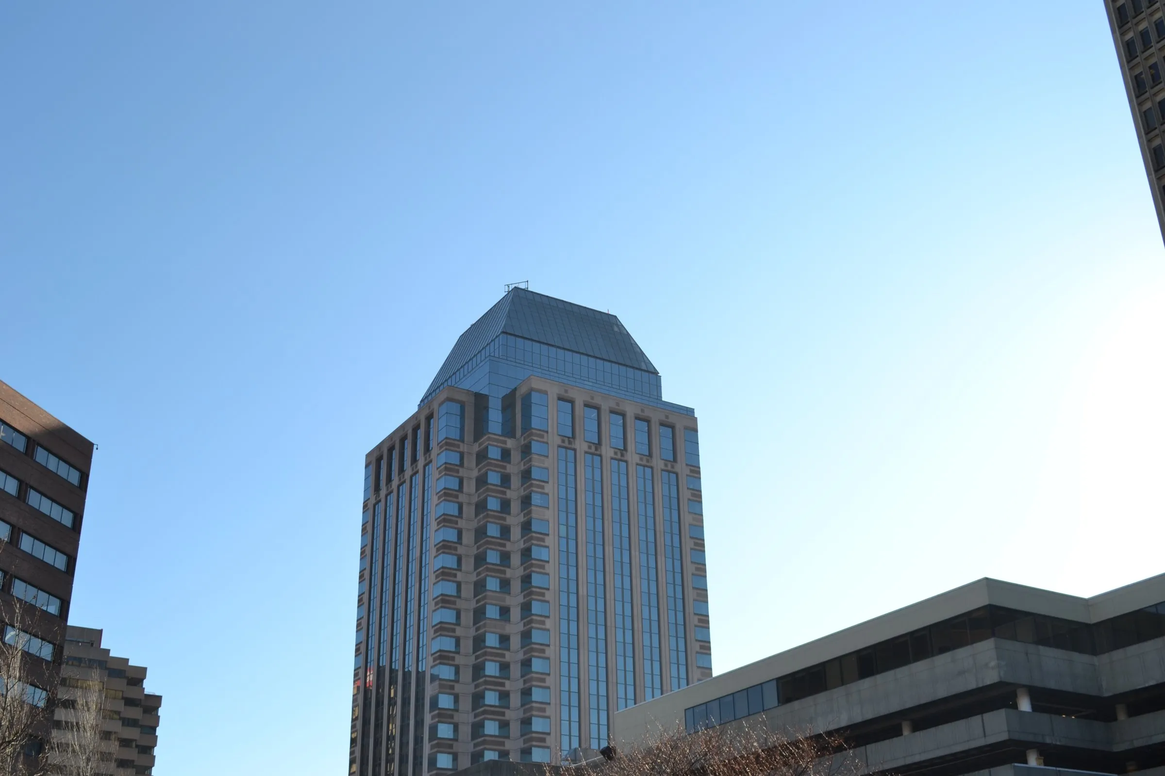 High-rise stone and glass office tower seen from street level